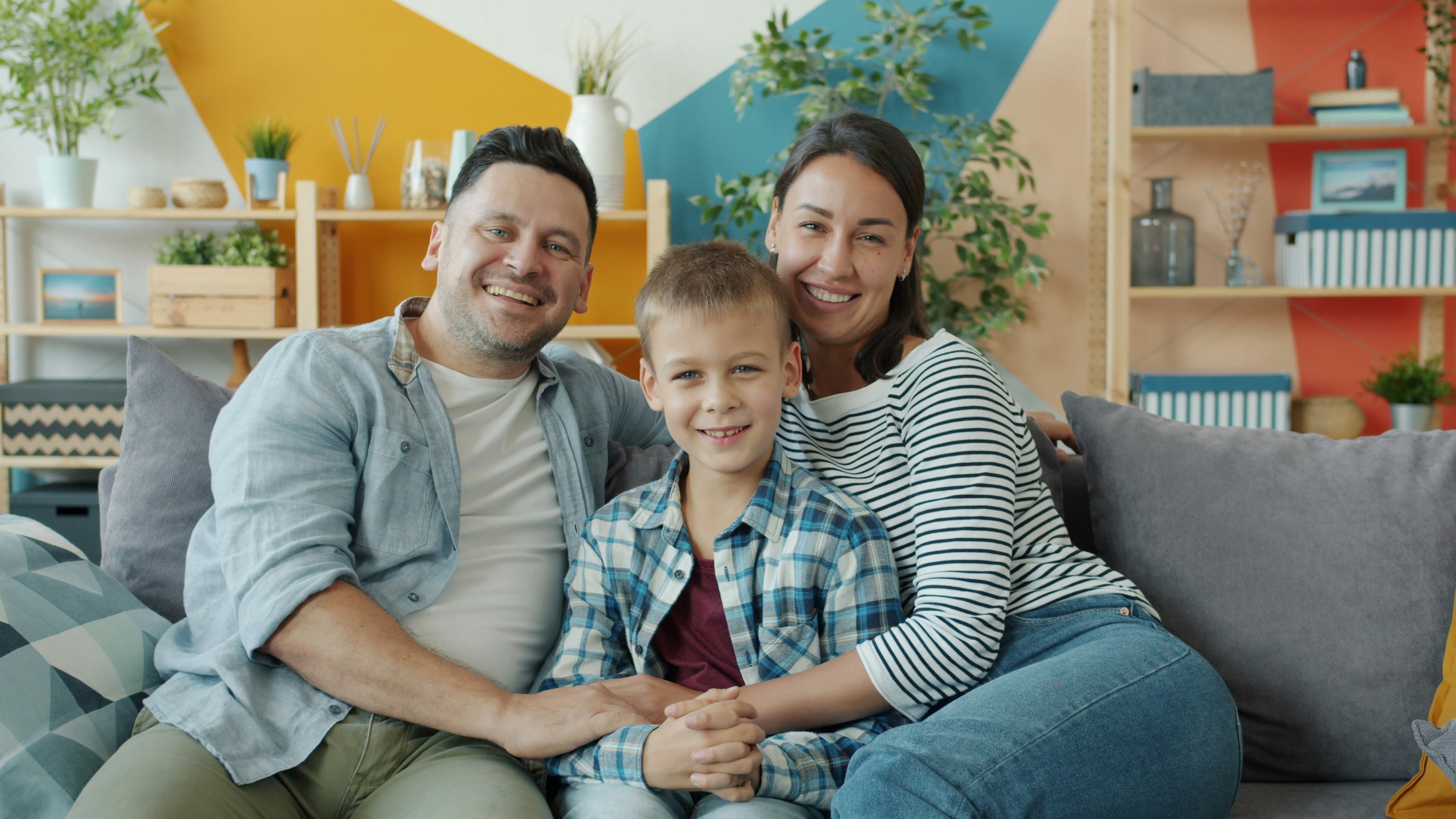 A smiling family sitting together on a couch at home